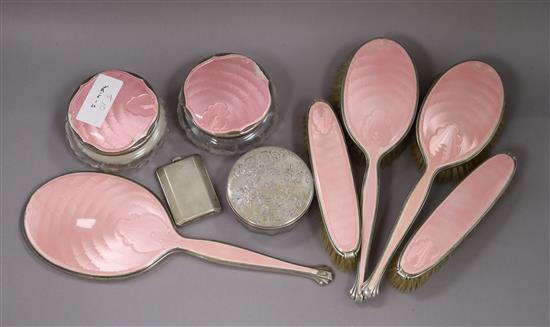 A 1930s matched eight piece silver and enamel dressing table set, a powder jar and silver match case.